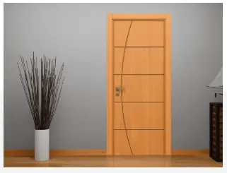Ambiente com uma porta de madeira lisa em tom mel, com frisos verticais, instalada em batente claro.